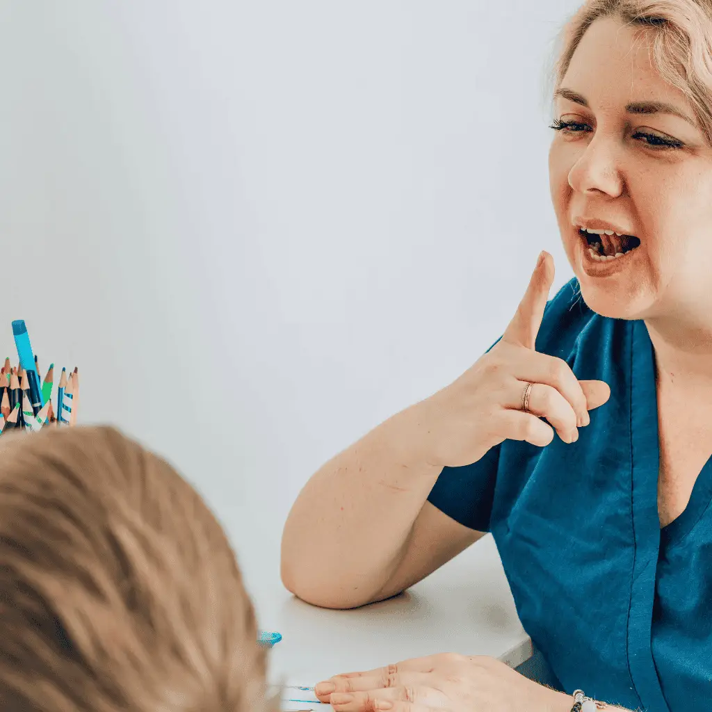 Speech language pathologist working with a young child in therapy session.