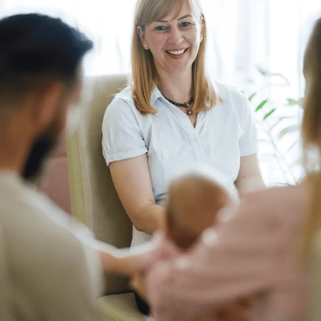 Therapist performing craniosacral therapy on a baby with parents present.