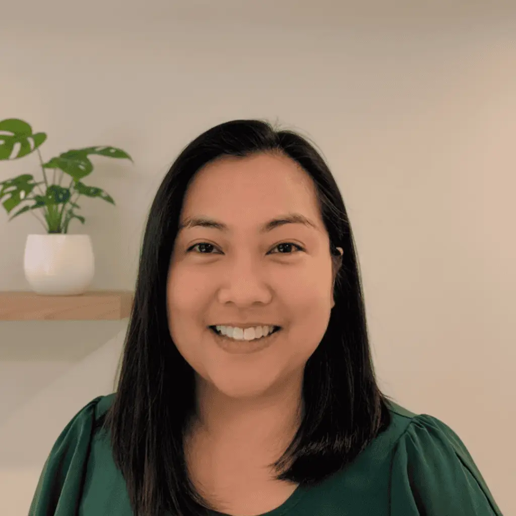 Professional woman smiling, promoting craniosacral therapy services for babies and families.